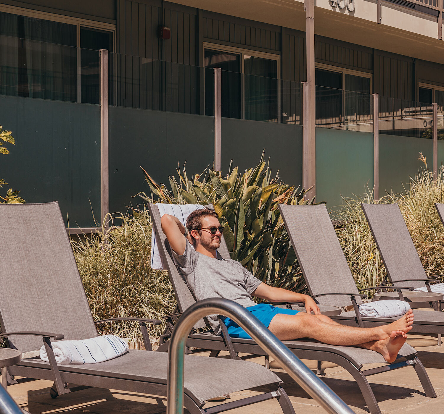 man lounging by pool