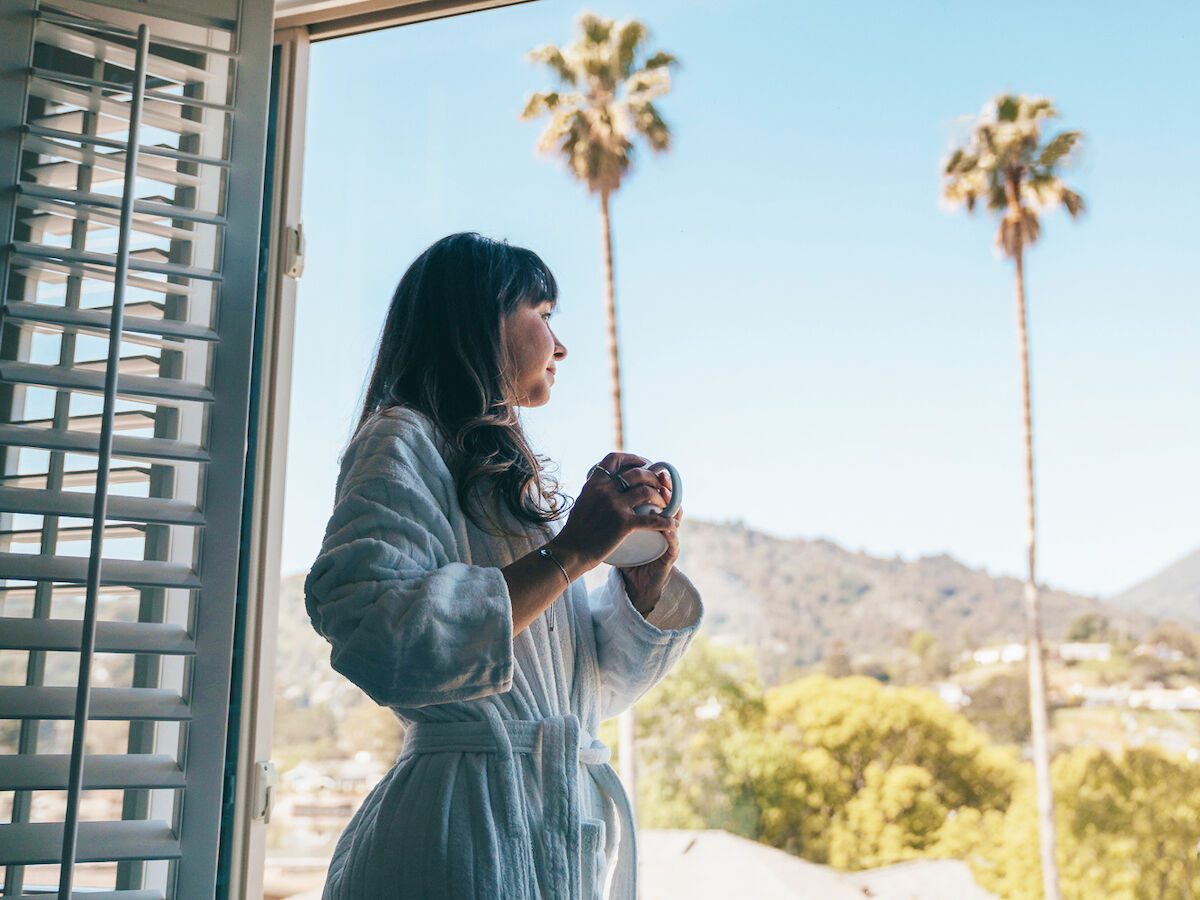 woman viewing outdoors from room balcony